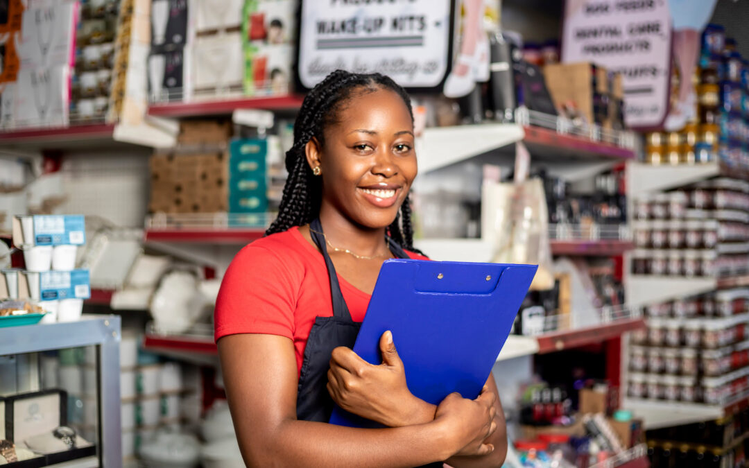 Young black woman with clipboard standing in her brick and mortar store